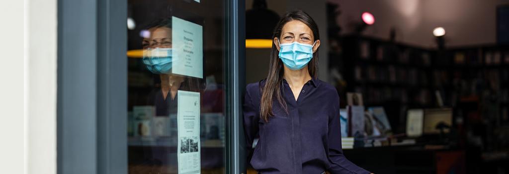 woman wearing a mask opening a door