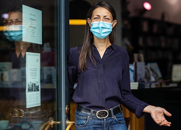 woman wearing a mask opening a door