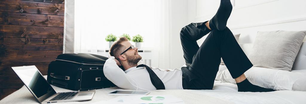 Male business traveller lying on hotel bed