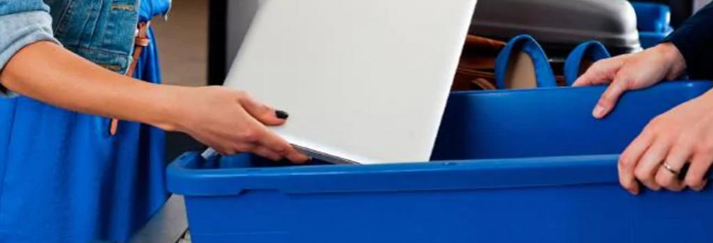 Person placing laptop on security belt