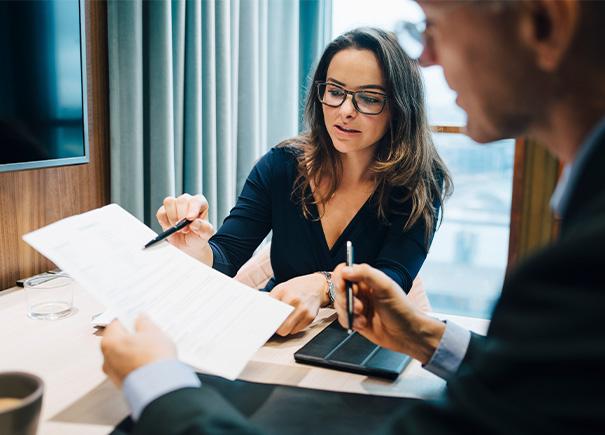 Woman explaining numbers on a page to coworker