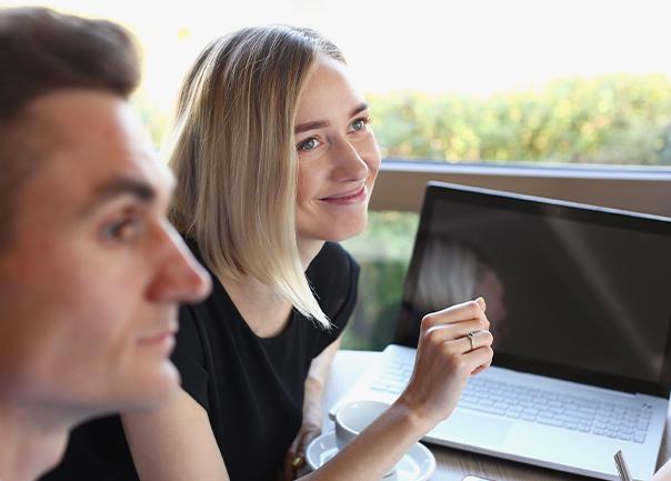 Man and woman smiling at desk.