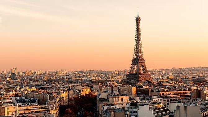 The Eiffel Tower at sunset overlooking Paris, a key destination for corporate travel as businesses plan flights for the upcoming Paris Olympics.