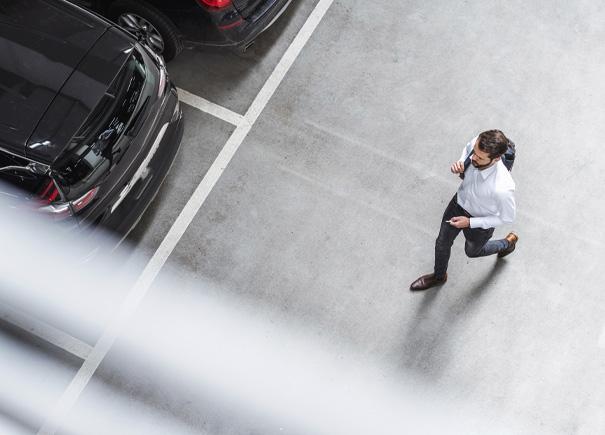 Man walking in office building parking lot